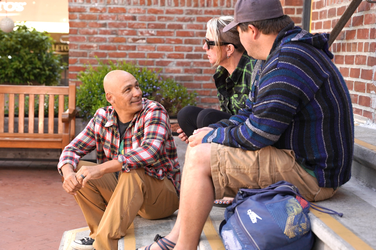 Three Veterans sitting on steps outside.